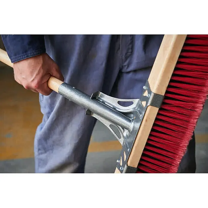 Freund Victoria Straßenbesen Profi - Arbeitsbreite: 60 cm, Material Borsten: Elaston, Rot, Natur - Nahaufnahme einer robusten Straßenbürste mit rotem Borstenkopf und Metallhalterung, die von einer Person gehalten wird.
