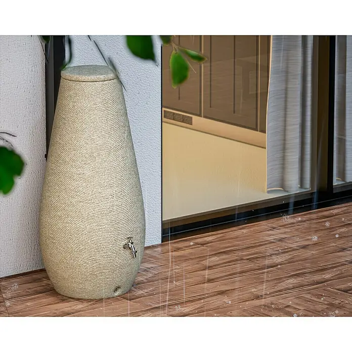 Arves Regenspeicher Drop - 200 l, Beige, 1 Stk. - Ein beigefarbenes, tropfenförmiges Wasserfass aus strukturiertem Material mit einem Hahn, das auf einer Holzterrasse steht.