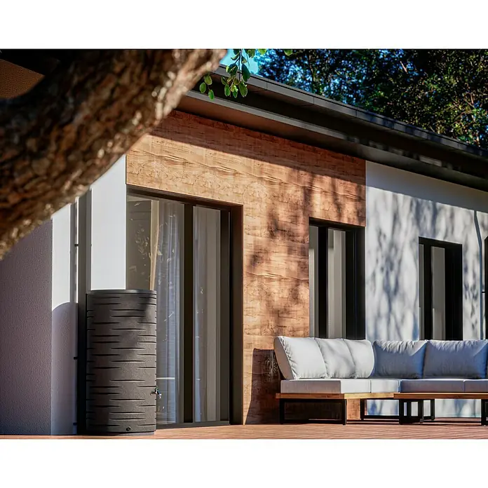 Arves Regenspeicher Freze - 410 l, Granit - Eine moderne Regenwassertonne vor einer Hauswand mit Holzakzenten, die eine stilvolle und nachhaltige Lösung zur Wassergewinnung bietet.