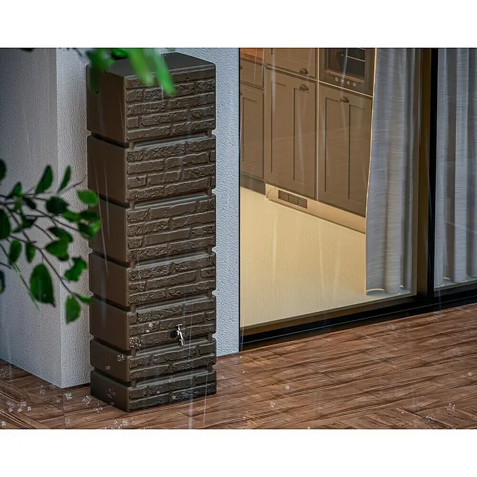 Arves Regenspeicher Tower - 350 l, Braun, 1 Stk. - Ein schmaler, turmartiger, kastenförmiger, brauner Wasserbehälter mit Ziegelsteindesign und einem Hahn steht neben einer Hauswand.