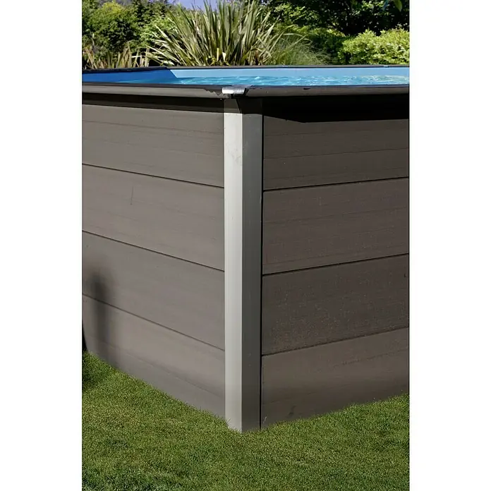 Gre Avantgarde WPC-Pool - L x B x H: 664 x 386 x 124 cm, 21.500 l, Dunkelgrau - Detailaufnahme eines braunen Gartenpools mit Holzverkleidung und einem silbernen Eckpfosten, umgeben von Rasen und Grünpflanzen.