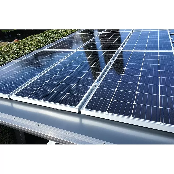 Ximax Solar-Set - 0% MwSt. gem. § 12 Abs. 3 UStG - 2.520 W, Passend für: Ximax Aluminium Design Carport Linea Sonderlänge 5558 x 2726 mm - Mehrere dunkelblaue Solarpaneele mit silbernen Rahmen, Sonnenlicht reflektierend, auf einer Metallstruktur im Freien installiert.