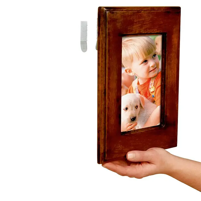 3M Command Cinta engomada 17202 - Blanco - Un marco de fotos marrón con una foto de un niño y un cachorro, montado en la pared con tiras adhesivas.