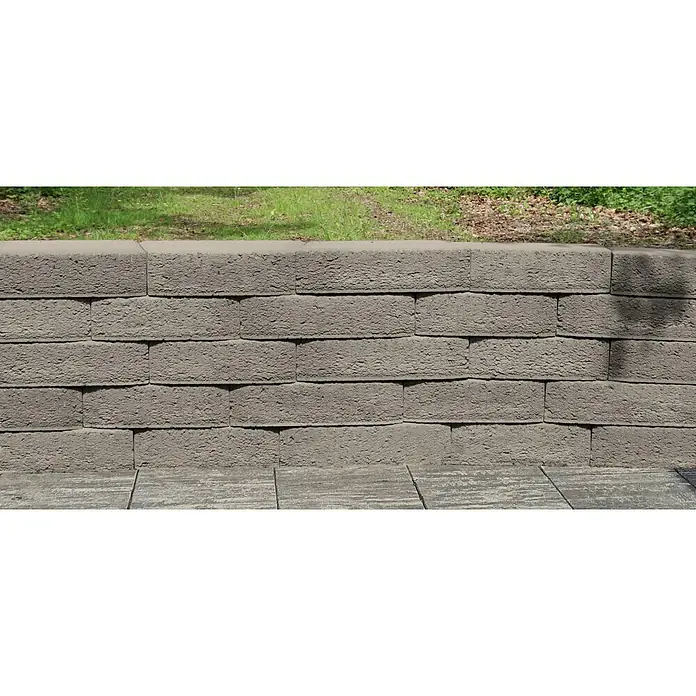 Christoph Mauerstein Antikblock - 30 x 15 x 7,5 cm, Grau, Beton - Nahaufnahme einer stabilen, grauen Stützmauer aus Betonsteinen, die Funktionalität und rustikale Ästhetik im Garten vereint.