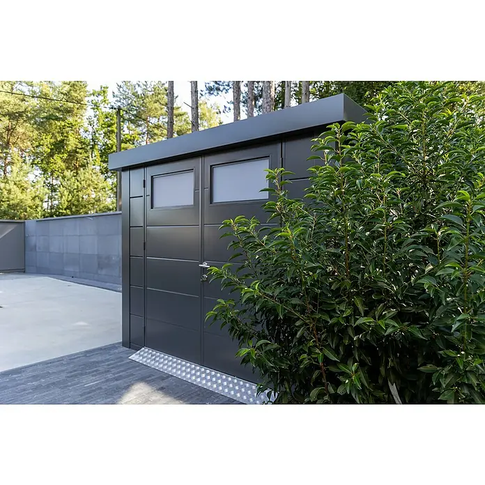 Telluria Metallgerätehaus Classico 3330 - Außenmaß inkl. Dachüberstand (B x T): 348 x 318 cm, Stahl, Anthrazit, Ohne Set - Moderne graue Garagenbox mit Fenstern und einem kleinen Busch davor, die sich nahtlos in die Umgebung einfügt.