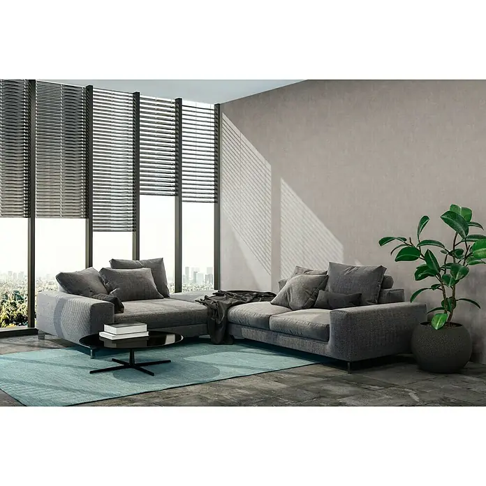 A.S. Création New Walls Vliestapete Beton - Hellgrau, Betonoptik, 10,05 x 0,53 m - Moderne Wohnlandschaft mit grauem Stoffbezug, stilvollem Couchtisch und Zimmerpflanze vor großen Fenstern mit Jalousien für ein gemütliches Ambiente.