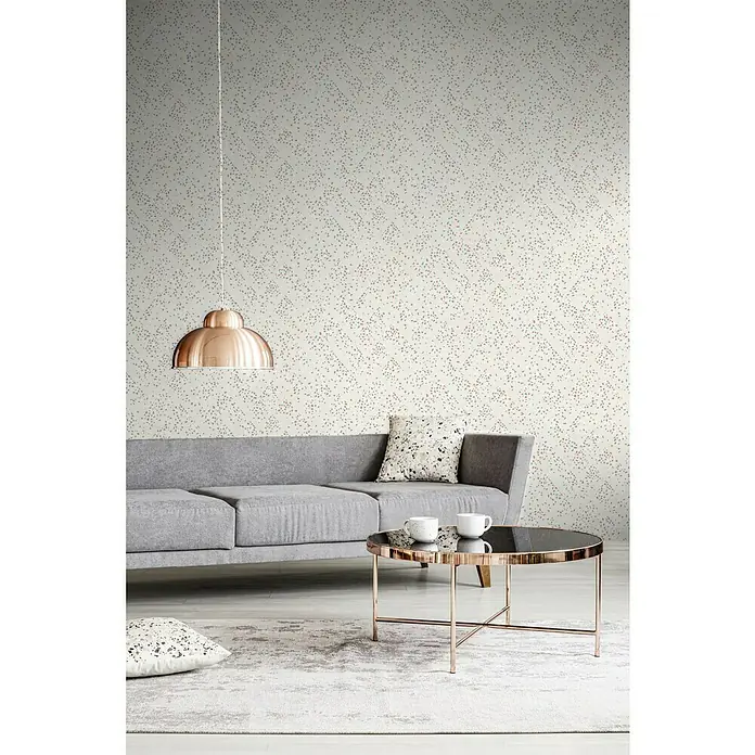 A.S. Création New Walls Vliestapete Grafik - Creme/Rosé, Grafisch, 10,05 x 0,53 m - Wohnzimmer mit einem grauen Sofa, einem runden Couchtisch mit zwei Tassen und einer Kupferleuchte über dem Sofa.