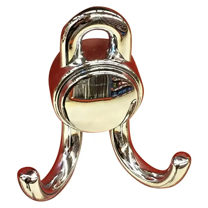 Häfele Gancho para colgar - Altura: 85 mm, Cromado pulido - Primer plano de un colgador de abrigos brillante de color plateado con dos brazos de gancho y un lazo para colgar, montado sobre una superficie roja.