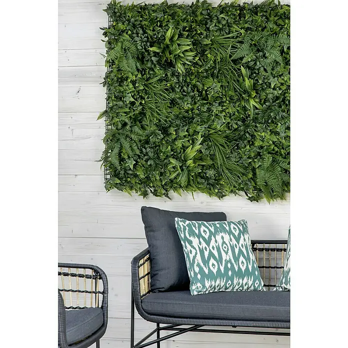 Faura Jardín vertical Salvaje - Plástico, L x An: 100 x 100 cm - Pared de plantas artificiales con vegetación exuberante que crea un ambiente relajante. La pared se complementa con cojines elegantes en un asiento.