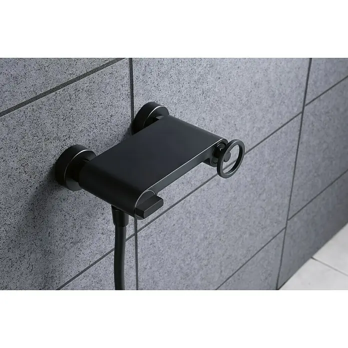 Imex Olimpo Grifo de ducha - Negro - Accesorio de ducha negro contra una pared de azulejos grises, que realza un diseño de baño moderno y elegante con su tono oscuro.