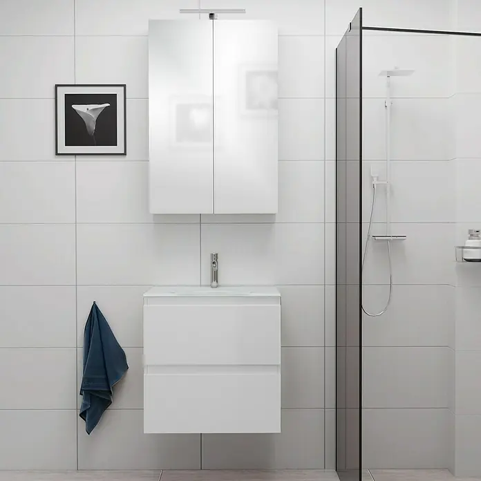 Camargue Espacio Badmöbel-Set E22 - 60 cm, Gama weiß glänzend - Badezimmer-Interieur mit weißem Waschbeckenunterschrank mit zwei Schubladen, einem Spiegelschrank, einer Dusche und einer Handtuchaufhängung.