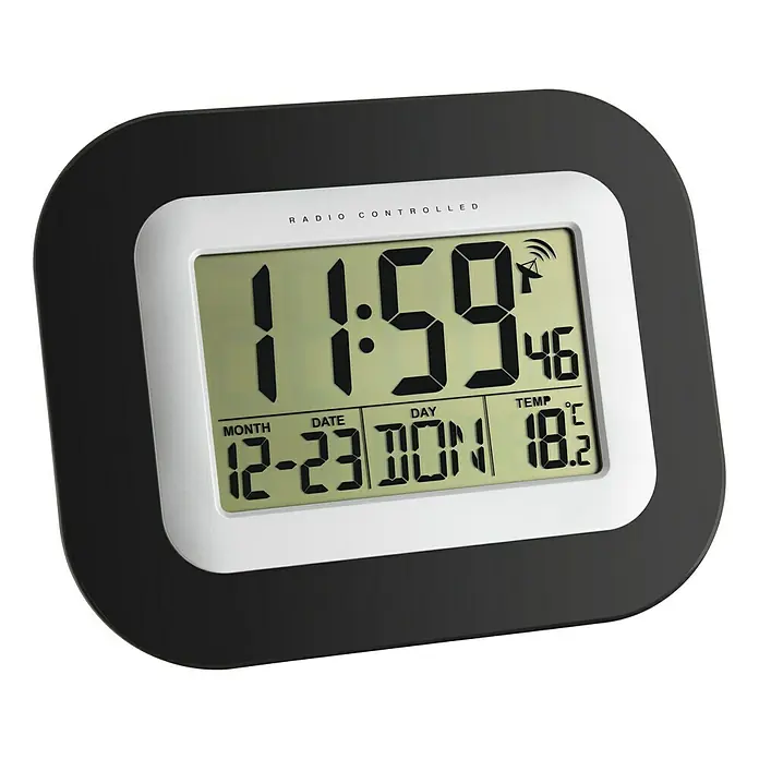 TFA Dostmann Funkuhr - 22,5 x 18 cm, Schwarz/Silber - Ein digitales Funkwanduhr mit Anzeige von Uhrzeit (11:59), Datum (12-23) und Temperatur (18.2°C).