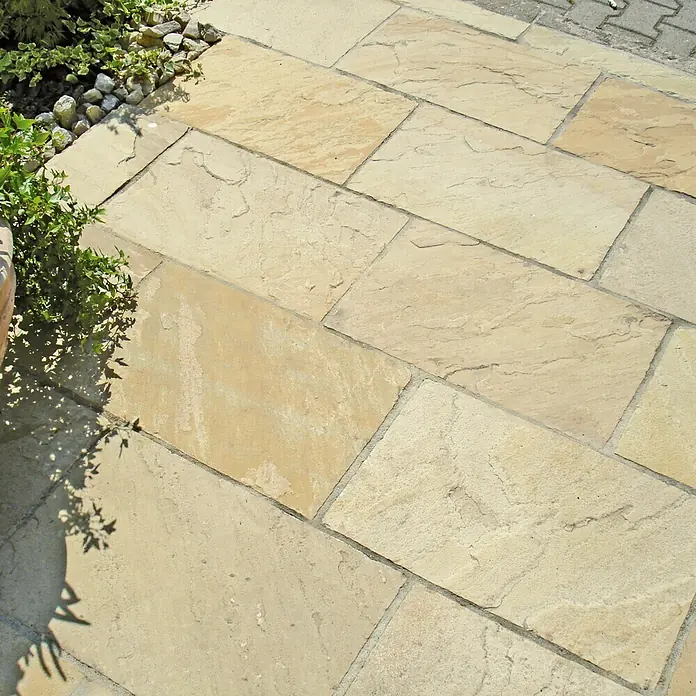 Terrassenplatte Indian Summer - 30 x 60 x 2,5 cm, Sandfarbe, Sandstein, Gespalten - Nahaufnahme von gelben Steinplatten, die ein elegantes Muster bilden. Perfekt für Terrassen und Wege.