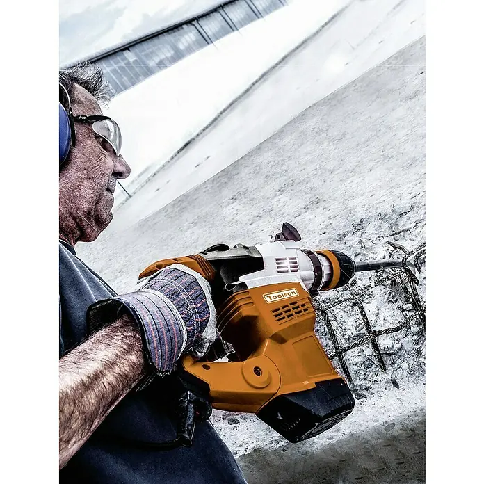 Toolson Kombihammer PRO-HM 9 MAX - 1.050 W, 9 J, SDS-Max-Aufnahme - Ein Bauarbeiter benutzt einen Toolson Abbruchhammer, um Beton auf einer Baustelle zu bearbeiten. Schutzkleidung wird getragen.