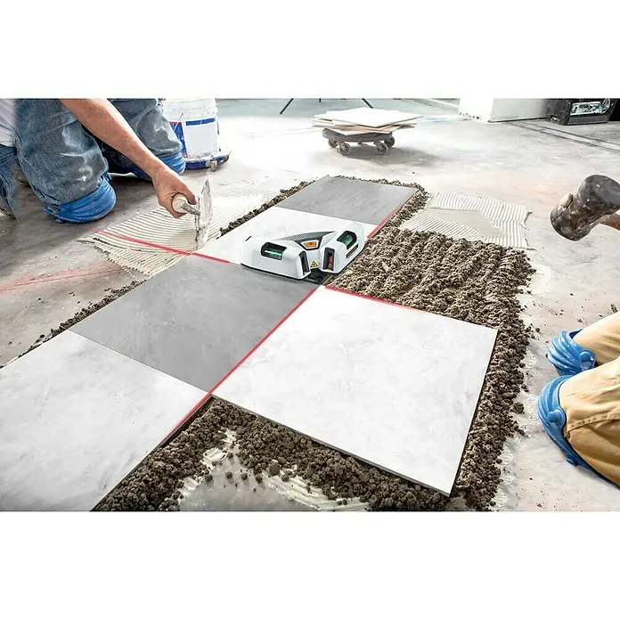 Laserliner Linienlaser SuperSquare-Laser 4 - Max. Arbeitsbereich: 15 m, Messgenauigkeit: 0,5 mm/m - Das Bild zeigt einen Fliesenleger bei der Arbeit mit einem Fliesenlaser, der rote Linien auf die Fliesen projiziert. Präzise und effiziente Verlegung.