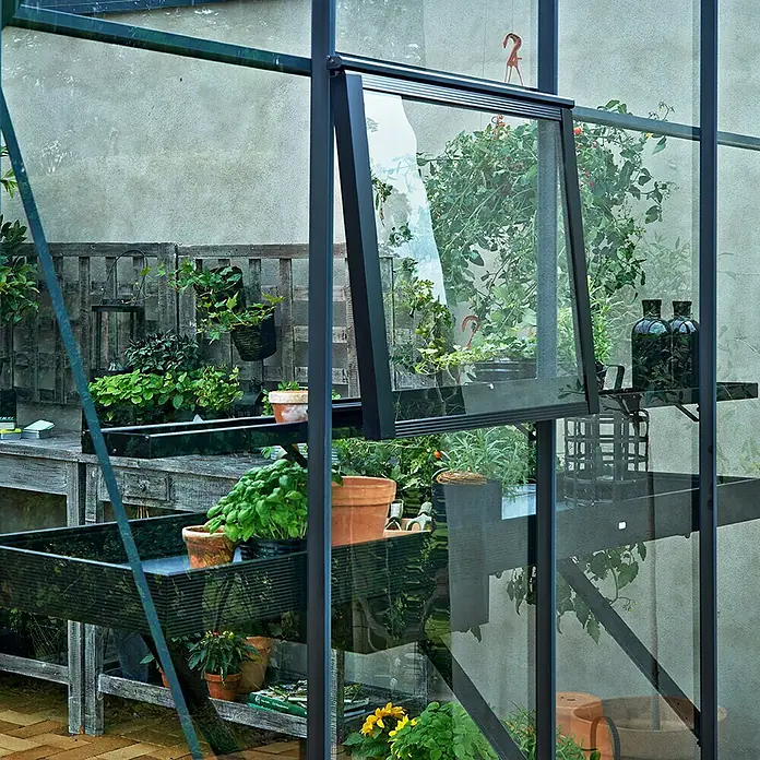 Juliana Gewächshaus-Tisch - 213 x 52 x 10 cm - Nahaufnahme eines Gewächshauses mit Fenster, das Pflanzen und Töpfe zeigt.