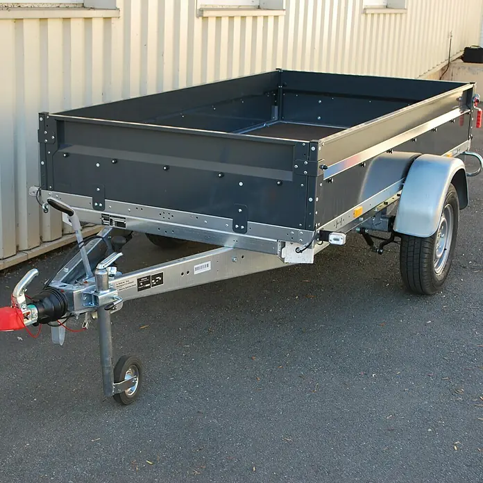 Stema Anhänger BASIC ST 1300-25-13.1 - Nutzlast: 1.040 kg, Einachser, Kasteninnenmaß: 251 x 128 x 35 cm, Gebremst - Ein detailreiches Bild eines neuen Anhängers mit silbernem Rahmen und grauer Ladefläche, ideal für Transportaufgaben.