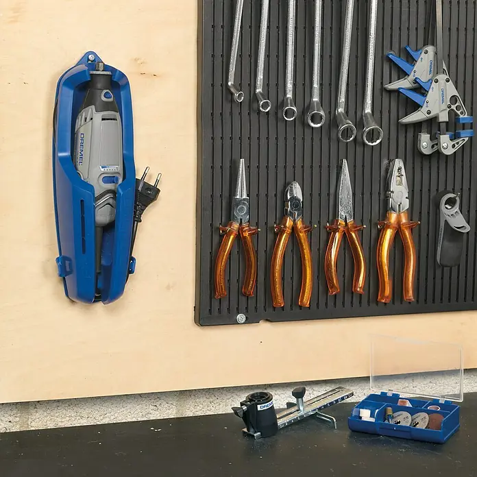 Dremel Multifunktionswerkzeug 3000-1/25 - 130 W - Werkstatt-Einrichtung mit Dremel Multifunktionswerkzeug in blauer Halterung, Werkzeugwand mit Schraubenschlüsseln und Zangen.