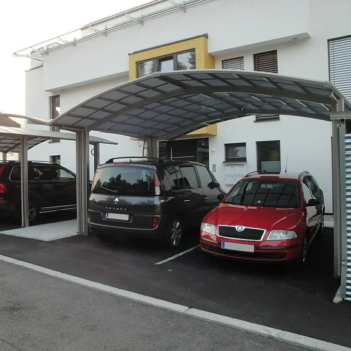 Ximax Carport Portoforte M 110 - Außenmaß inkl. Dachüberstand (B x T): 5,42 x 4,95 m, Doppelcarport, Edelstahloptik, Schneelast: 137 kg/m² - Ein moderner Carport mit drei geparkten Autos, darunter ein roter Skoda, unter einer geschützten Überdachung, die vor Witterungseinflüssen schützt.