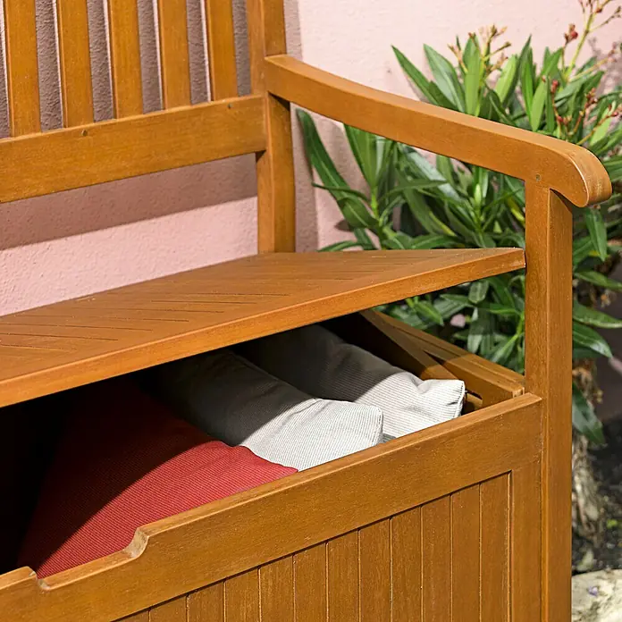 Sunfun Diana Gartenbank - L x B x H: 107 x 57 x 90 cm, Eukalyptus - Eine Holzbank mit offenem Stauraum, in dem rote und gestreifte Kissen liegen, ideal für den Garten oder die Terrasse.