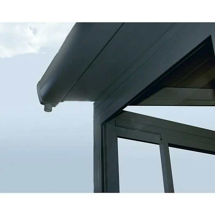 Palram – Canopia Wintergarten San Remo - B x T x H: 4,25 x 3 x 3,1 m, Anthrazitgrau - Detailaufnahme eines modernen Aluminium-Terrassendachs mit Regenrinne und klarer Linienführung vor einem hellen Himmel.