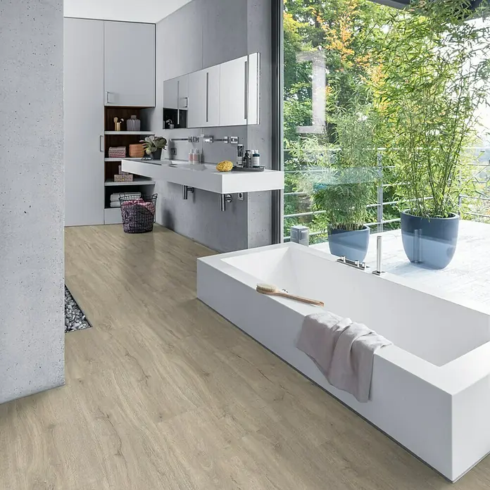 Living by Haro Hydrostar Designboden - Eiche Trient Grau, Landhausdiele, 1.282 x 235 x 6,5 mm - Ein Badezimmer mit einem modernen, freistehenden, rechteckigen Badewanne, hellem Holzboden und großen Fenstern mit Grünblick.