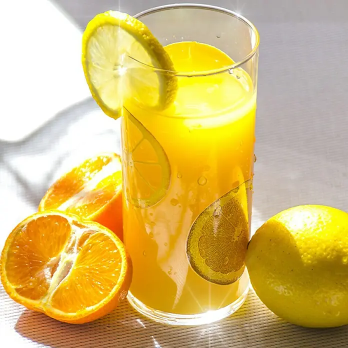Piardino Zitronenbaum - Citrus limon, Topfgröße: 20 cm - Erfrischendes Glas Orangensaft mit Zitronenscheibe und halbierten Orangen. Ideal für einen sonnigen Tag, voller Vitamin C und Geschmack.