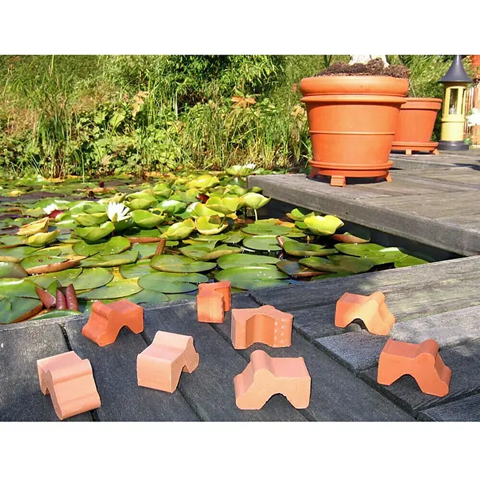 Terrakottafuß Set - Höhe: 4,2 cm, Naturmaterialien, Terracotta, 3 Stk. - Nahaufnahme von Terracotta-Ziegeln auf einem Holzsteg neben einem Teich mit Seerosen und Pflanzgefäßen.
