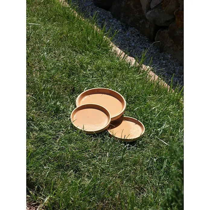 Blumentopf-Untersetzer - Außenmaß (Ø x H): 13 x 1,9 cm, Naturmaterialien, Hell - Drei Terrakotta-Pflanzenuntersetzer liegen im Gras und warten auf ihre Verwendung im Garten. Praktische Gartenhelfer für den Außenbereich.