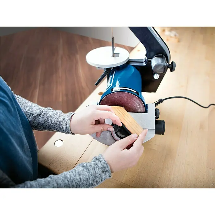 Scheppach Band- & Tellerschleifer BTS 700 - 250 W, Durchmesser Schleifteller: 125 mm - Eine Person benutzt eine Scheibenschleifmaschine, um ein Stück Holz zu bearbeiten. Präzision und Handwerkskunst vereint.