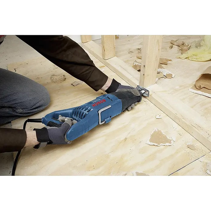 Bosch Professional Säbelsäge GSA 1100 E - 1.100 W, Hublänge: 28 mm - Auf dem Bild ist eine blaue Bosch-Säbelsäge in Aktion zu sehen, die Holz schneidet. Sie ist ein Elektrowerkzeug für Bau- und Abbrucharbeiten.