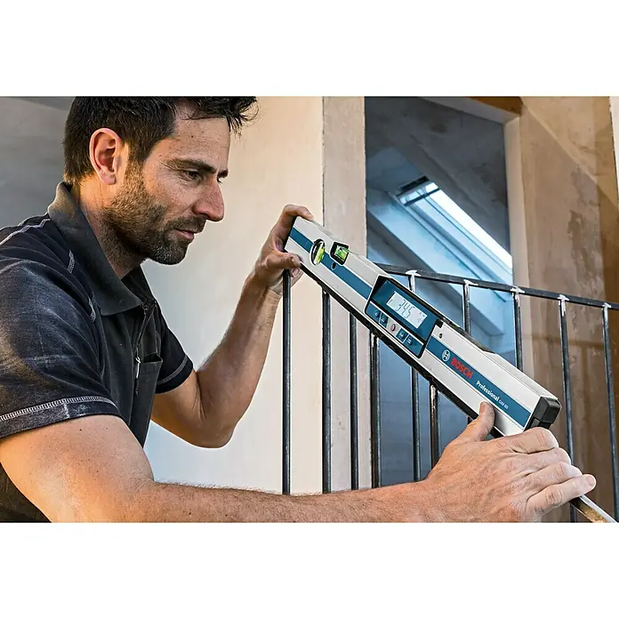 Bosch Professional Digitale Wasserwaage GIM 60 - 600 mm, Messbereich: 0 ° - 360 ° (4 x 90 °) - Ein Mann benutzt eine digitale Wasserwaage von Bosch Professional, um die Neigung eines Geländers zu messen.