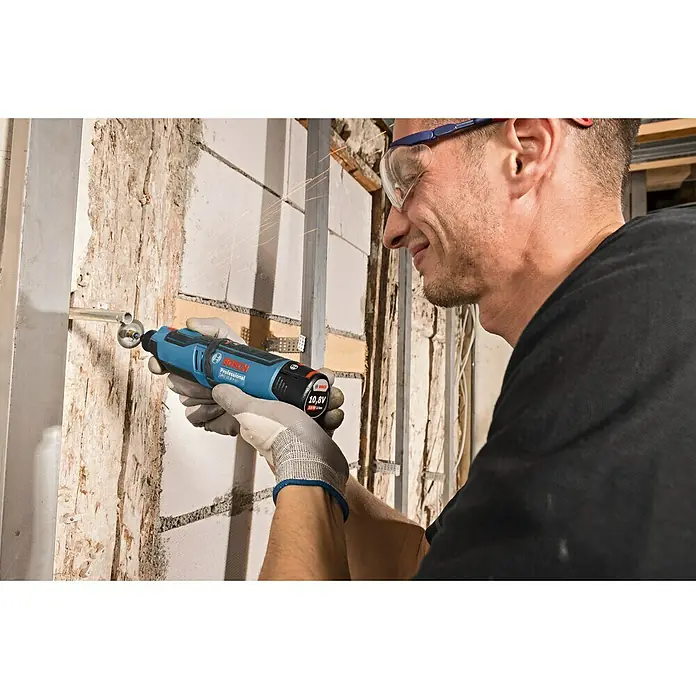 Bosch Professional Akku-Multifunktionswerkzeug GRO 12V-35 - 12 V, Leerlaufdrehzahl: 5.000 U/min - 35.000 U/min - Ein Handwerker benutzt einen blauen Bosch Professional Akku-Bohrschrauber mit 10,8V, um eine Metallstange zu bearbeiten.