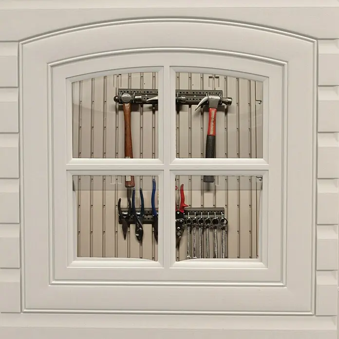 Lifetime Gerätehaus Sky - Außenbreite inkl. Dachüberstand: 240 cm, Außentiefe inkl. Dachüberstand: 305 cm, Stahl, Lichtgrau/Anthrazit - Werkzeuge hinter einem weißen Fensterrahmen aufgehängt, darunter Hämmer, Zangen und Schraubenschlüssel auf einer Werkzeugwand.