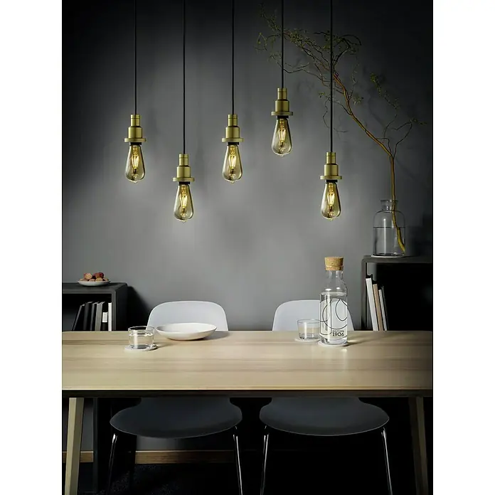Osram Schnurpendel Vintage 1906 Pendulum Gold - Gold, 200 cm, 60 W, E27 - Diese Aufnahme zeigt eine Reihe von Pendelleuchten mit Edison-Glühbirnen über einem Esstisch, die ein warmes und einladendes Ambiente schaffen.