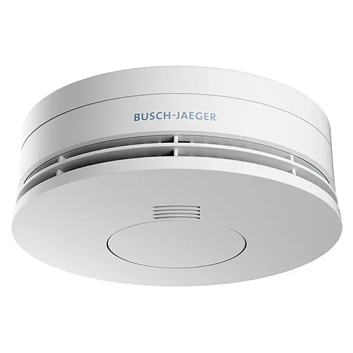 Busch-Jaeger Rauchwarnmelder - 12 cm, Batterielaufzeit: 10 Jahre, 85 dB - Eine Nahaufnahme eines weißen Busch-Jaeger Rauchmelders mit Lüftungsschlitzen und der Aufschrift BUSCH-JAEGER.