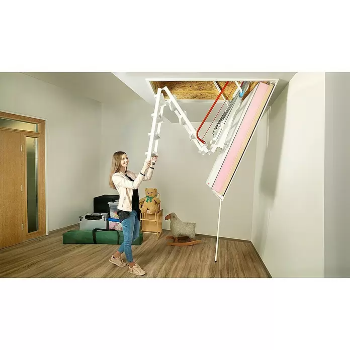 Wippro Bodentreppe Klimatec 160 - 120 x 60 cm, Wärmedämmung: 0,34 W/(m²K) - Frau fährt eine weiße, segmentierte Bodentreppe mit roten Stützen aus der Decke aus, die eine isolierte Zugangsblende zeigt.