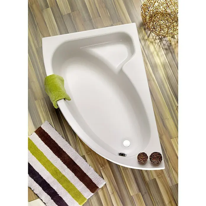Ottofond Raumsparbadewanne Sansibar B - 150 x 97 cm, Sanitäracryl, Weiß, Links - Blick von oben auf eine moderne, dreieckige Badewanne mit Handtuch, Badematte und dekorativen Kugeln auf einem Holzboden.