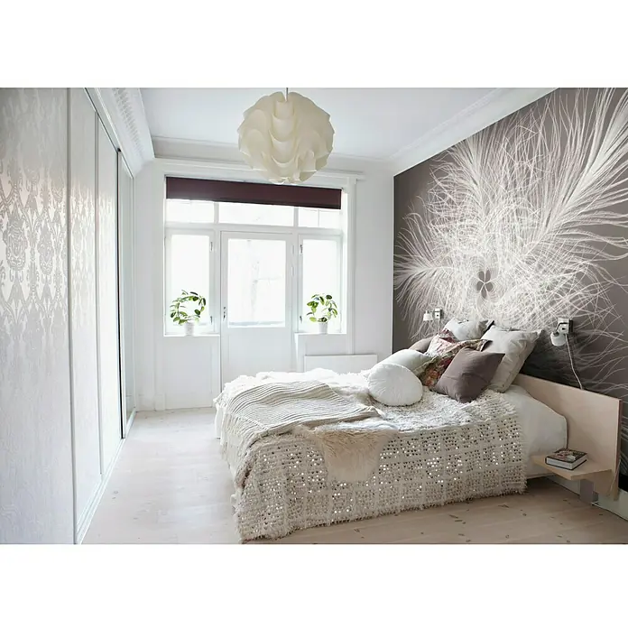 Komar Into Illusions Fototapete Federstern - 4 -tlg., B x H: 368 x 248 cm, Vlies - Schlafzimmer mit einem weißen Bett mit vielen Kissen und einer glitzernden Tagesdecke vor einer grauen Wand mit einem weißen Blumenmuster.