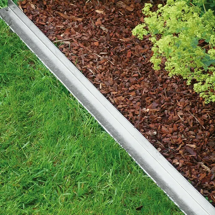 Bellissa Rasenkante Comfort - 118 x 9 cm, Metall, Verzinkt, Mähkante - Das Bild zeigt eine Rasenkante aus Metall, die sauber Rasen und Mulch voneinander trennt und so für einen gepflegten Garten sorgt.