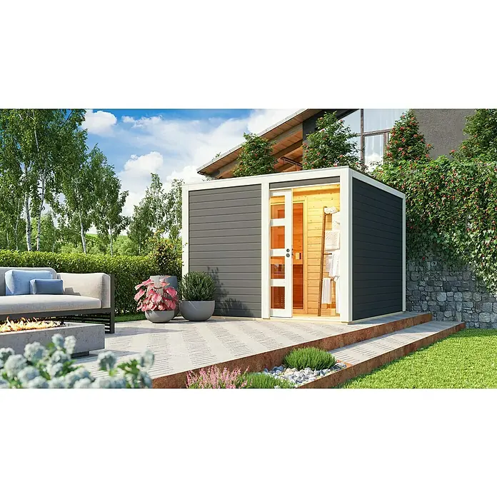 Karibu Saunahaus Cuben - 9 kW Saunaofen mit externer Steuerung, Terragrau, L x B x H: 276 x 276 x 210 cm - Diese Aufnahme zeigt eine moderne Außensauna mit grauem Äußeren und offenem Holzeingang, umgeben von einer malerischen Gartengestaltung.