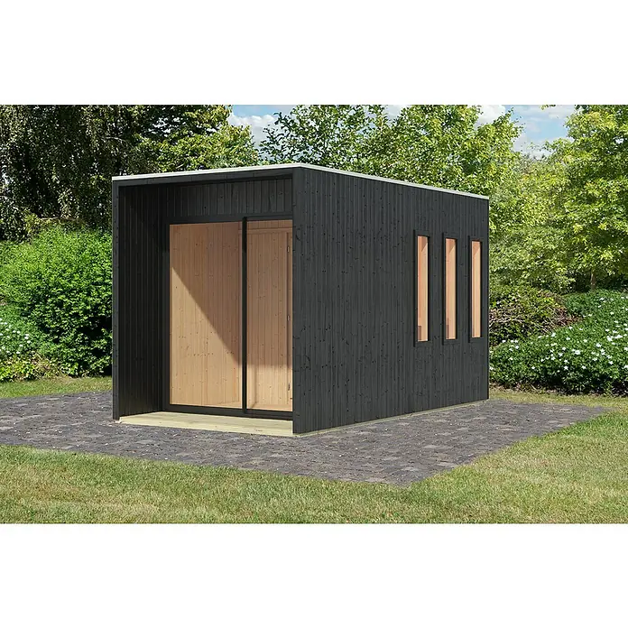 Karibu Saunahaus Miramar - L x B x H: 429 x 219,5 x 244 cm, Schwarz, Ohne Ofen - Moderne, schwarze Gartensauna mit Holzverkleidung und drei schmalen Fenstern, die auf einer gepflasterten Fläche in einem üppigen Garten steht.