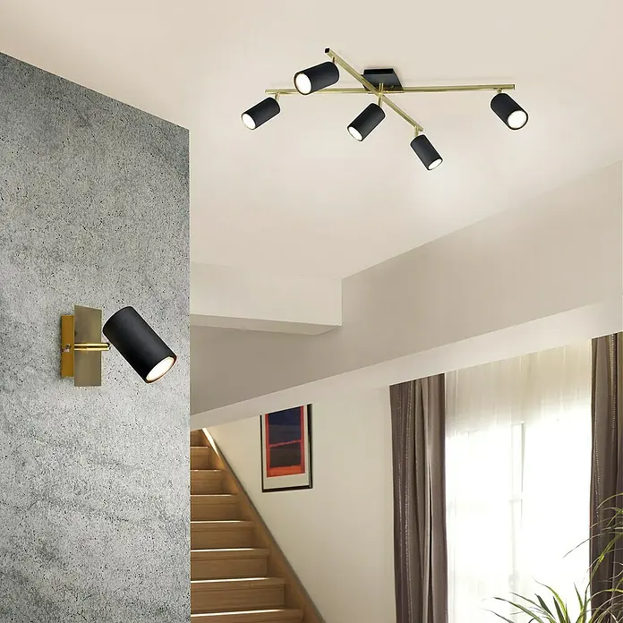 Trio Leuchten Marley Deckenstrahler - 175 W, L x B x H: 57,4 x 77,4 x 22,4 cm, Schwarz/Gold, GU10 - Eine stilvolle Innenaufnahme mit modernen, schwarzen und goldenen Leuchten an Wand und Decke, die ein warmes Licht verbreiten und die Eleganz des Raumes betonen.