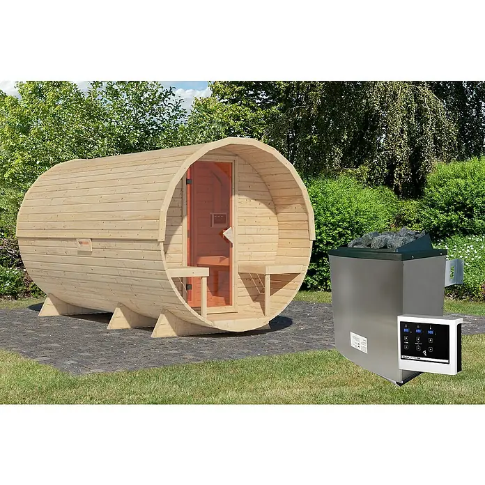 Karibu Fasssauna - L x B x H: 385 x 225 x 229 cm, 9 kW Saunaofen mit externer Steuerung, Anzahl Liegen: 4 Stk. - Eine Fasssauna aus hellem Holz und ein Saunaofen mit Steinen stehen im Garten. Ideal für entspannende Wellness-Momente im Freien.