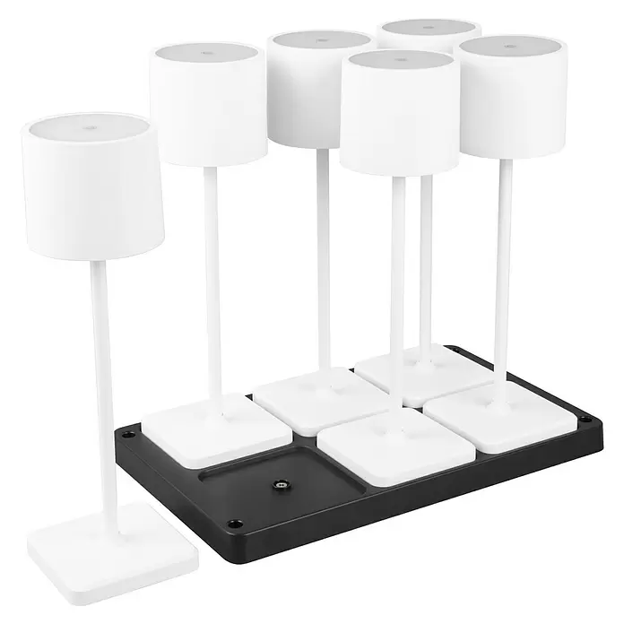 Reality Leuchten Akku-Tischleuchte FERNANDEZ + Ladestation - 6 W, L x B x H: 26 x 42,6 x 40 cm, Weiß, Mehrfarbig - Sechs weiße zylindrische Lampen mit hohen Stielen auf einer schwarzen rechteckigen Basis. Sie haben quadratische weiße Ständer, und ein Steckplatz auf der Basis ist leer.