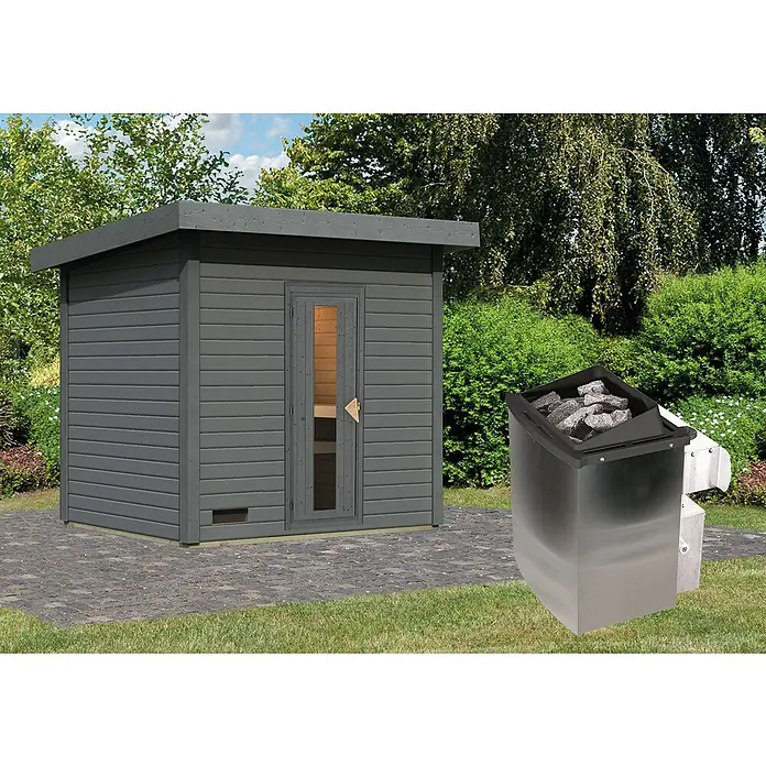 Karibu Saunahaus Hytti - 9 kW Saunaofen mit integrierter Steuerung, Terragrau, L x B x H: 196 x 231 x 228 cm - Außenansicht einer modernen Gartensauna mit grauem Anstrich und einem danebenstehenden Saunaofen mit Lavasteinen.