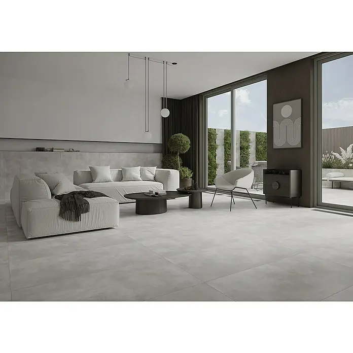 Feinsteinzeugfliese Big Show XXL - 59,8 x 119,8 cm, Grau, Matt - Helle Bodenfliesen im Wohnzimmer mit modernem Sofa und elegantem Sessel, die für eine stilvolle Atmosphäre sorgen.