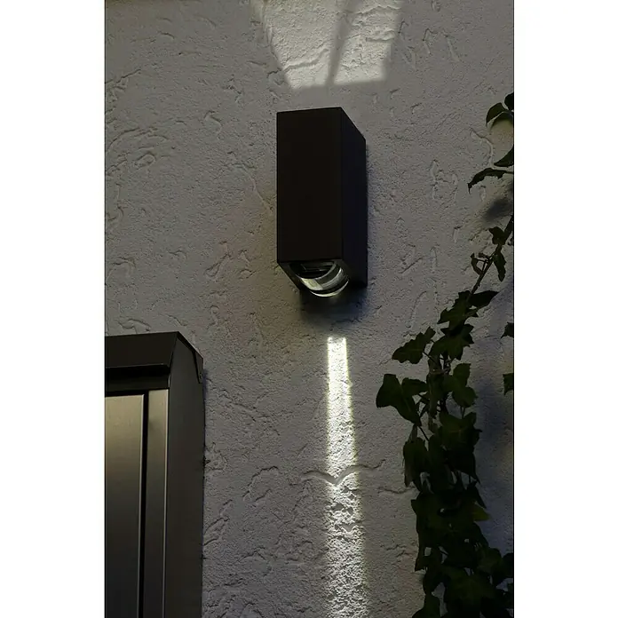 Lutec Aplique exterior LED Evans - 12 W, 19,2 x 7 x 10,9 cm, Antracita, Claro, IP54 - Lámpara de exterior con diseño moderno. La lámpara tiene un color oscuro y proyecta un haz de luz brillante en la pared.