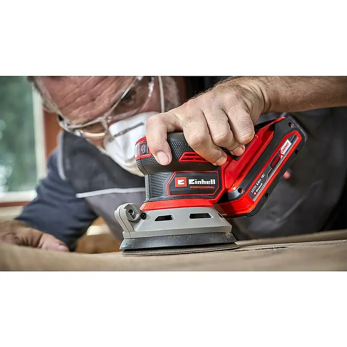 Einhell Power X-Change 18V Akku-Exzenterschleifer TP-RS 18/32 Li BL-Solo - 18 V, Ohne Akku, 125 mm - Ein Mann benutzt einen Einhell Akku-Exzenterschleifer auf einem Holzbrett. Das Gerät ist rot und schwarz und trägt das Einhell-Logo.
