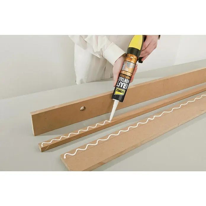 UHU Kraft Montagekleber Universal - 470 g, Kartusche, 1 Stk. - Eine Tube UHU Kraft Montage Klebstoff wird auf Holzstücke aufgetragen, um sie zu verbinden. Ideal für DIY-Projekte und Reparaturen.